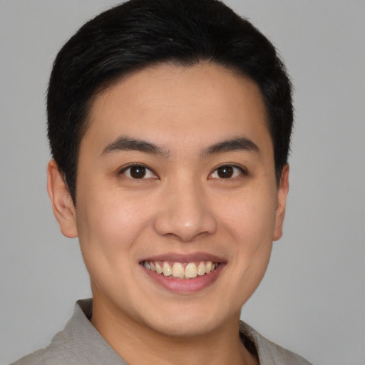 Joyful asian young-adult male with short  brown hair and brown eyes