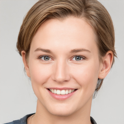 Joyful white young-adult female with medium  brown hair and grey eyes