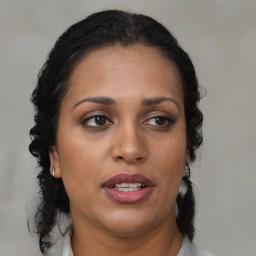 Joyful black adult female with medium  brown hair and brown eyes