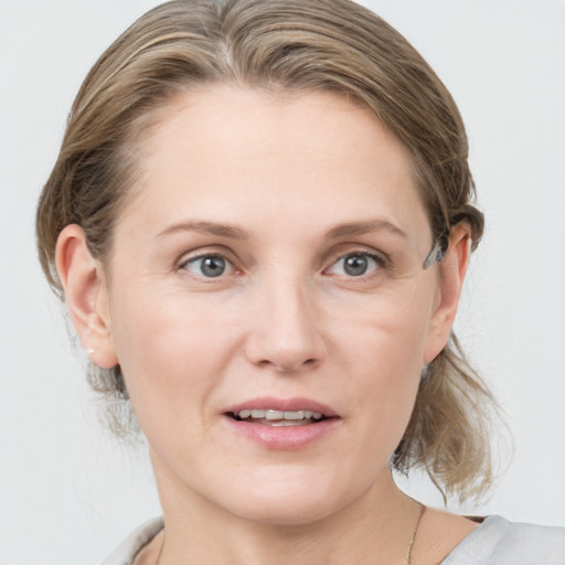 Joyful white young-adult female with medium  brown hair and blue eyes