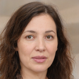 Joyful white adult female with long  brown hair and brown eyes