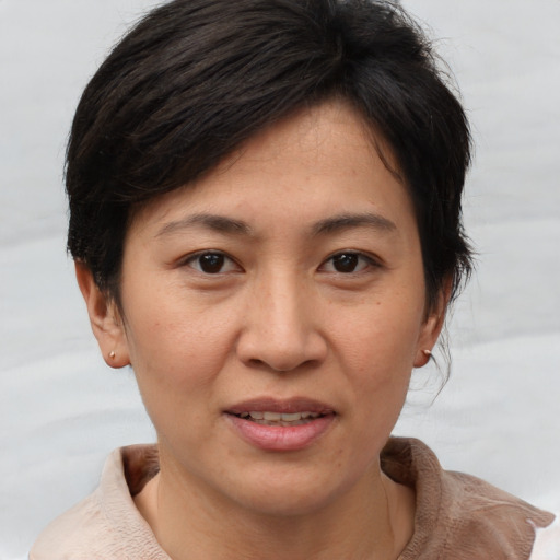 Joyful asian adult female with short  brown hair and brown eyes