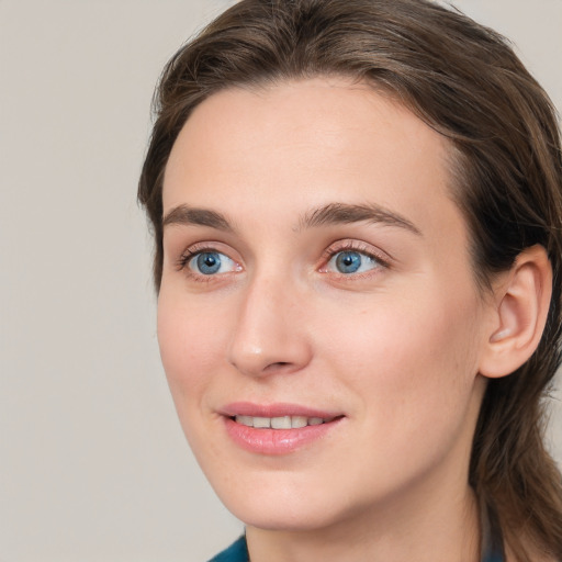 Joyful white young-adult female with long  brown hair and blue eyes