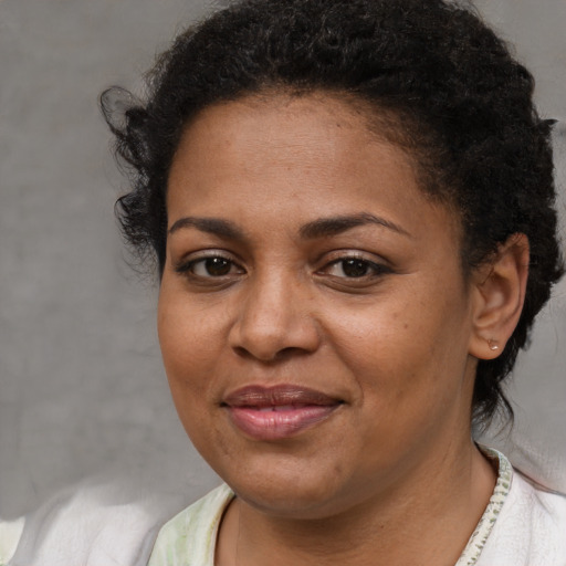 Joyful black adult female with short  brown hair and brown eyes