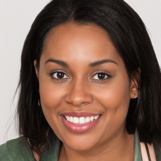 Joyful black young-adult female with long  brown hair and brown eyes