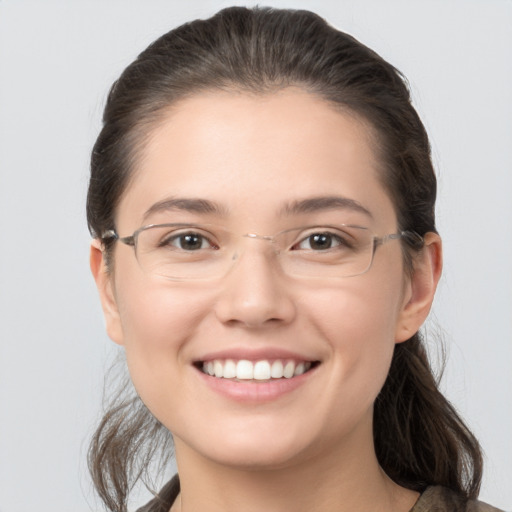 Joyful white young-adult female with medium  brown hair and grey eyes