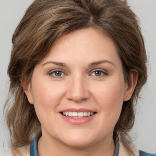 Joyful white young-adult female with medium  brown hair and grey eyes