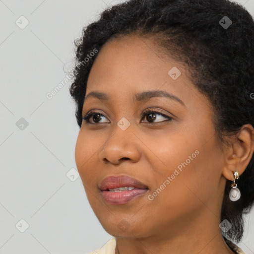 Joyful black young-adult female with long  black hair and brown eyes