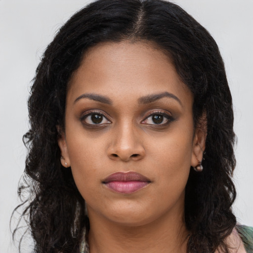 Joyful black young-adult female with long  brown hair and brown eyes
