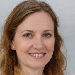 Joyful white adult female with long  brown hair and brown eyes