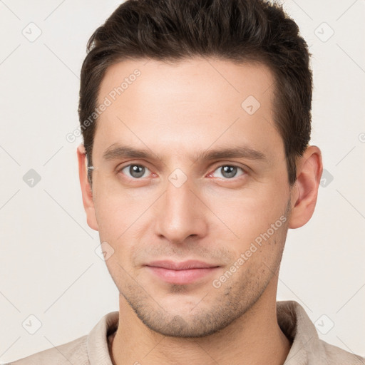 Joyful white young-adult male with short  brown hair and grey eyes