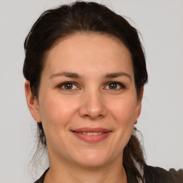 Joyful white young-adult female with medium  brown hair and grey eyes