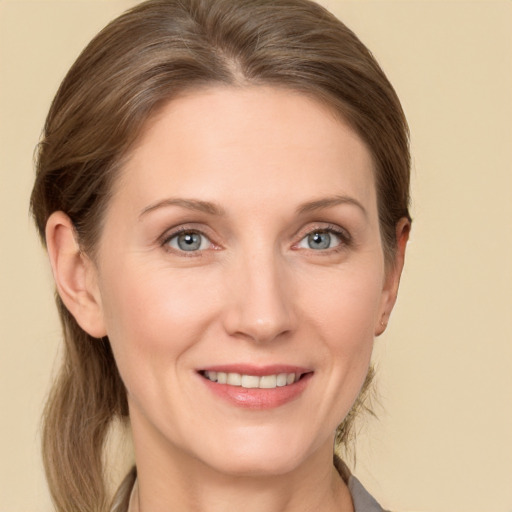 Joyful white adult female with long  brown hair and grey eyes