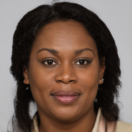 Joyful black young-adult female with long  brown hair and brown eyes