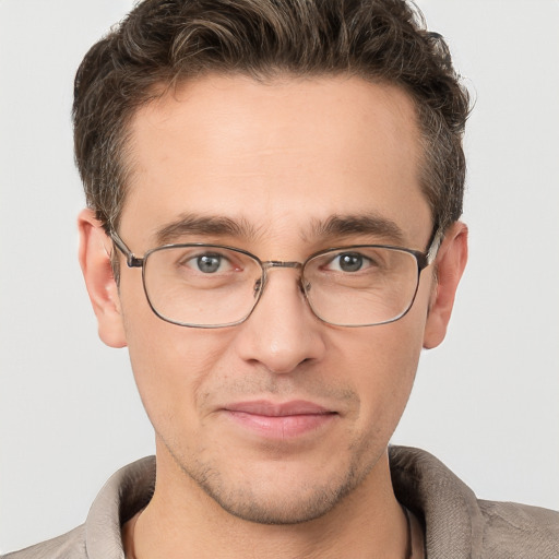 Joyful white young-adult male with short  brown hair and grey eyes