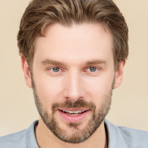 Joyful white young-adult male with short  brown hair and grey eyes