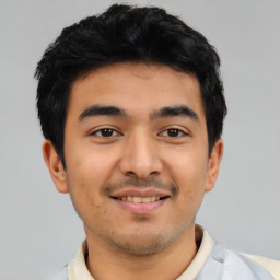 Joyful latino young-adult male with short  black hair and brown eyes