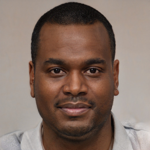 Joyful black young-adult male with short  brown hair and brown eyes