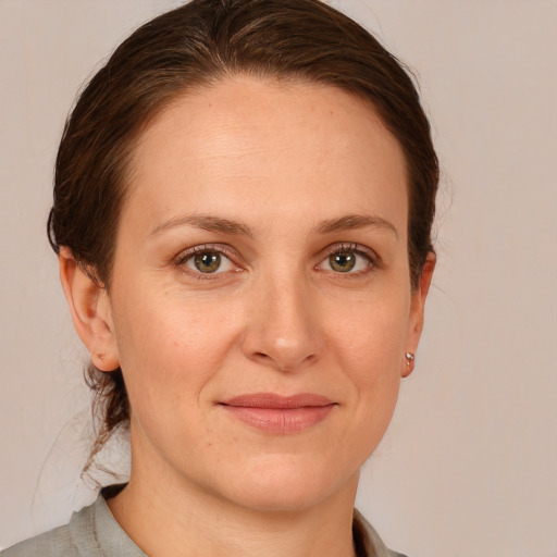 Joyful white young-adult female with medium  brown hair and grey eyes