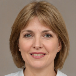 Joyful white adult female with medium  brown hair and grey eyes