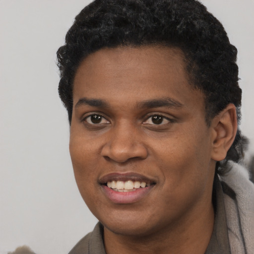 Joyful black young-adult male with short  black hair and brown eyes