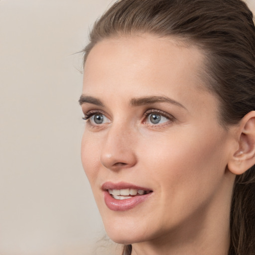 Joyful white young-adult female with long  brown hair and grey eyes