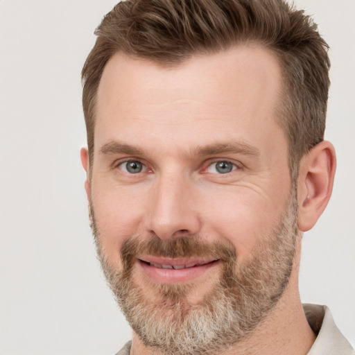 Joyful white adult male with short  brown hair and grey eyes