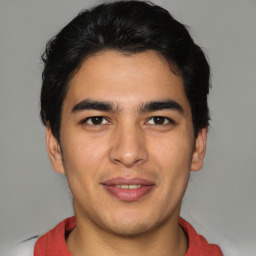 Joyful latino young-adult male with short  brown hair and brown eyes