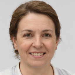 Joyful white adult female with medium  brown hair and grey eyes