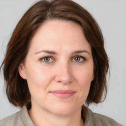 Joyful white adult female with medium  brown hair and grey eyes