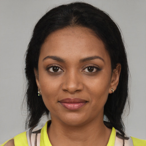Joyful black young-adult female with medium  brown hair and brown eyes