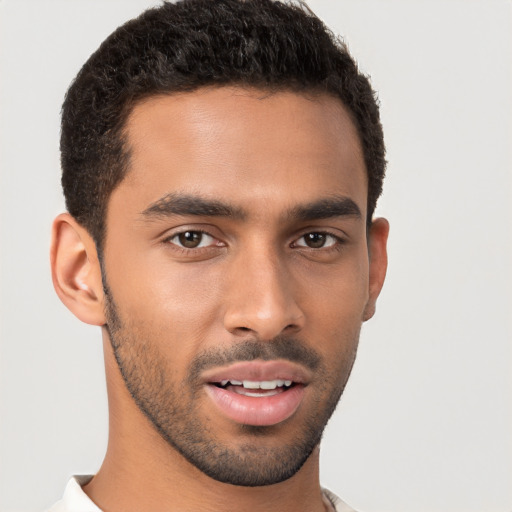 Joyful latino young-adult male with short  brown hair and brown eyes