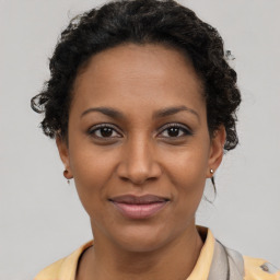 Joyful black young-adult female with short  brown hair and brown eyes