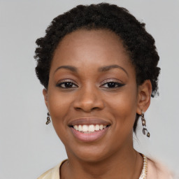 Joyful black young-adult female with long  brown hair and brown eyes