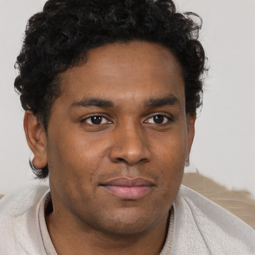Joyful black young-adult male with short  brown hair and brown eyes