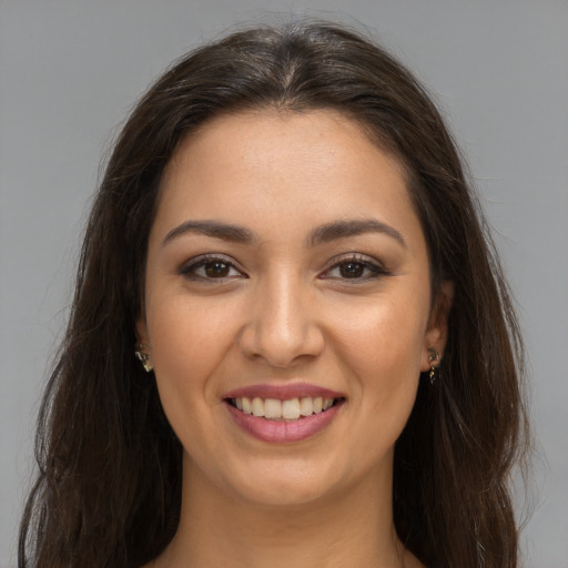 Joyful white young-adult female with long  brown hair and brown eyes