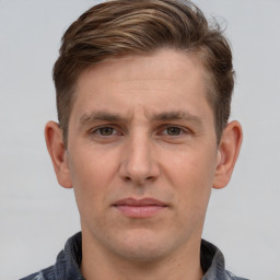 Joyful white young-adult male with short  brown hair and grey eyes