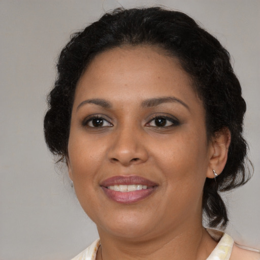 Joyful black adult female with medium  brown hair and brown eyes