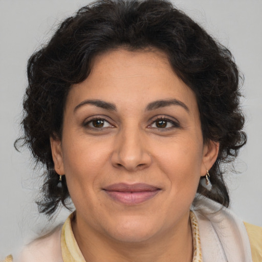 Joyful latino adult female with medium  brown hair and brown eyes