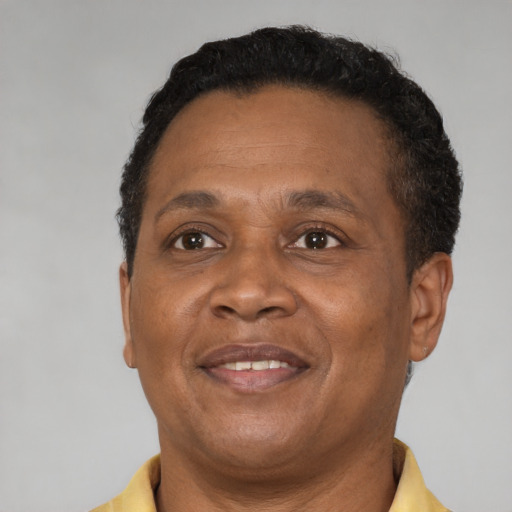 Joyful black adult male with short  brown hair and brown eyes