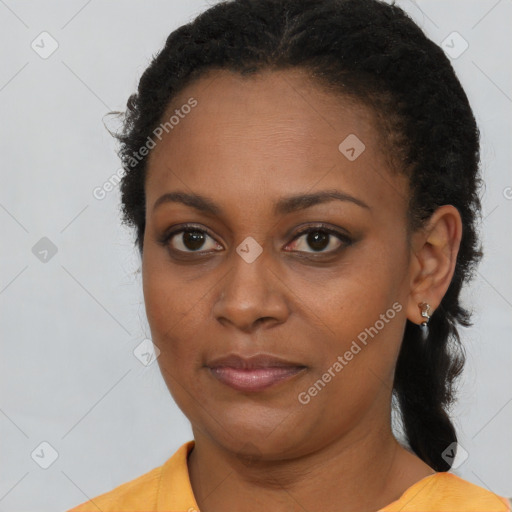 Joyful black young-adult female with long  brown hair and brown eyes