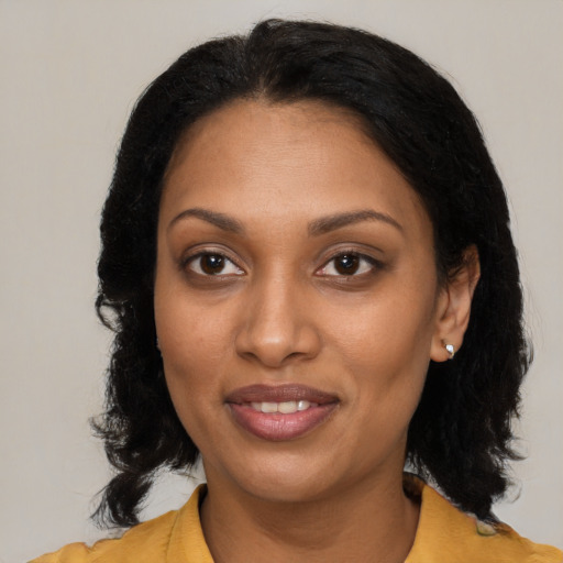 Joyful black adult female with medium  brown hair and brown eyes