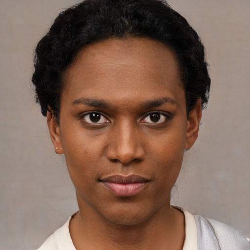 Joyful black young-adult female with short  black hair and brown eyes