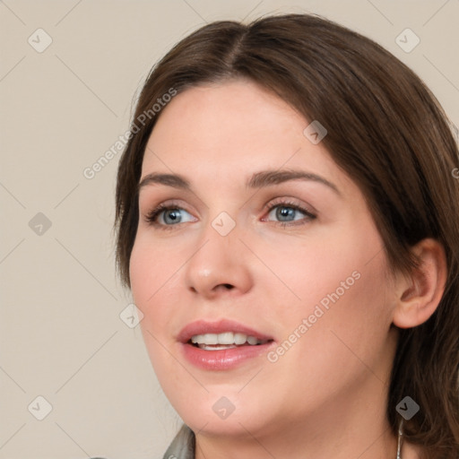 Joyful white young-adult female with medium  brown hair and grey eyes