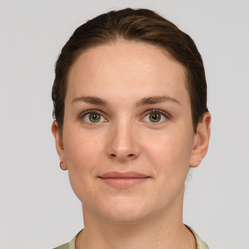 Joyful white young-adult female with short  brown hair and grey eyes