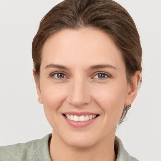 Joyful white young-adult female with short  brown hair and grey eyes