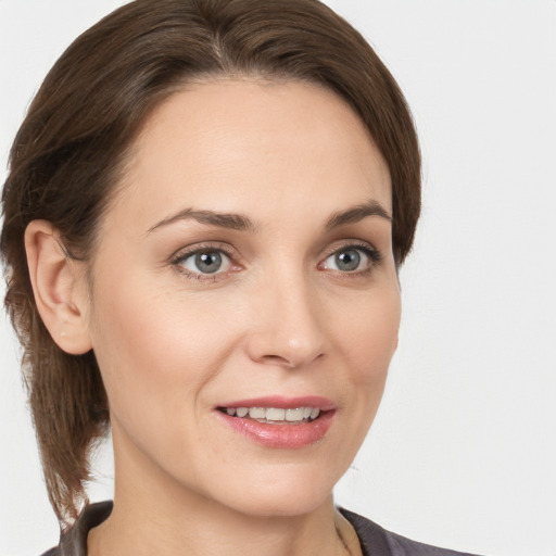 Joyful white young-adult female with medium  brown hair and grey eyes