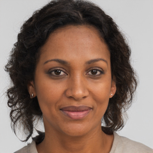 Joyful black adult female with medium  brown hair and brown eyes
