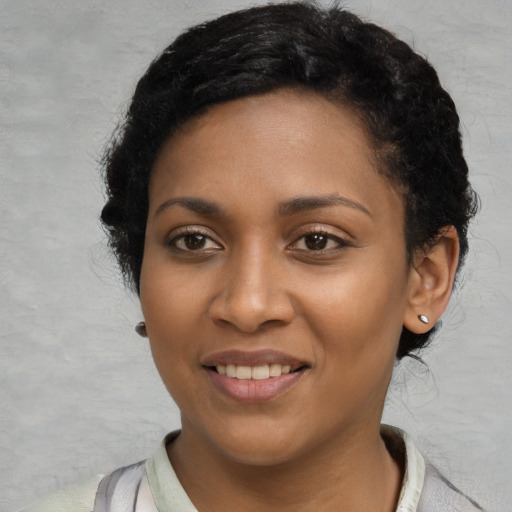 Joyful black young-adult female with short  black hair and brown eyes