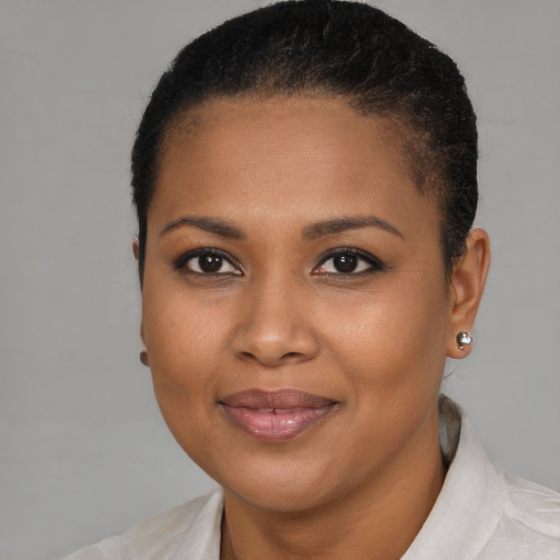 Joyful black young-adult female with short  brown hair and brown eyes